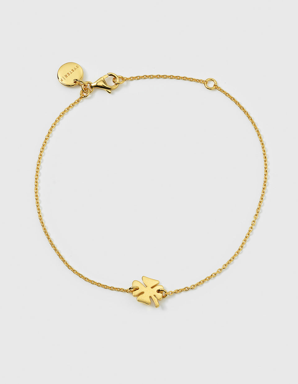 A product shot of the Bring Me Luck Bracelet Gold, laid out in a circle to display its delicate chain and central four-leaf clover charm.