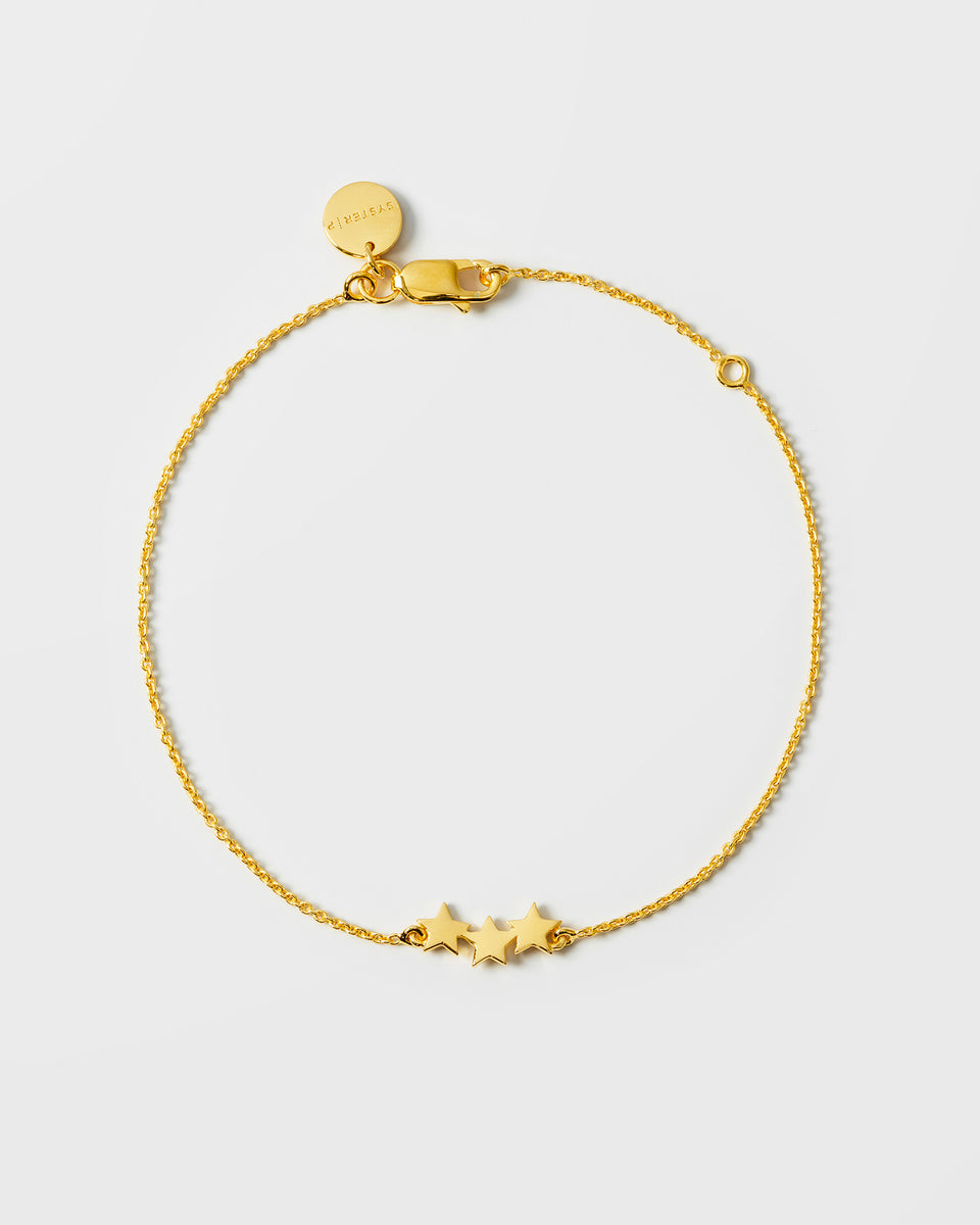 A product shot of the Snap Triple Star Bracelet in gold, laid out in a circle to display its design of a fine chain adorned with three small star charms.