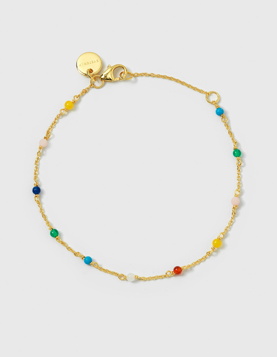 A product shot of the Santa Monica Bracelet in gold, laid out in a circle to display its chain design adorned with small, multicolored gemstone beads. The beads are Yellow Jade, Pink Opal, Sodalite, Green Onyx, Blue Color Reconstituted Turquoise, Vit Agate and Carnelian.