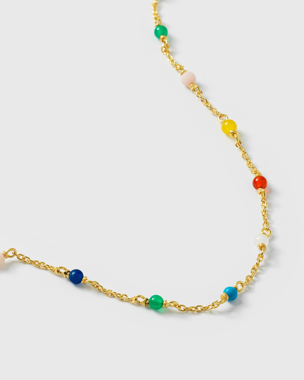 A close-up shot of the Santa Monica Bracelet in gold, displaying its fine chain design adorned with a variety of small, colorful gemstone beads: Yellow Jade, Pink Opal, Sodalite, Green Onyx, Blue Color Reconstituted Turquoise, Vit Agate and Carnelian.