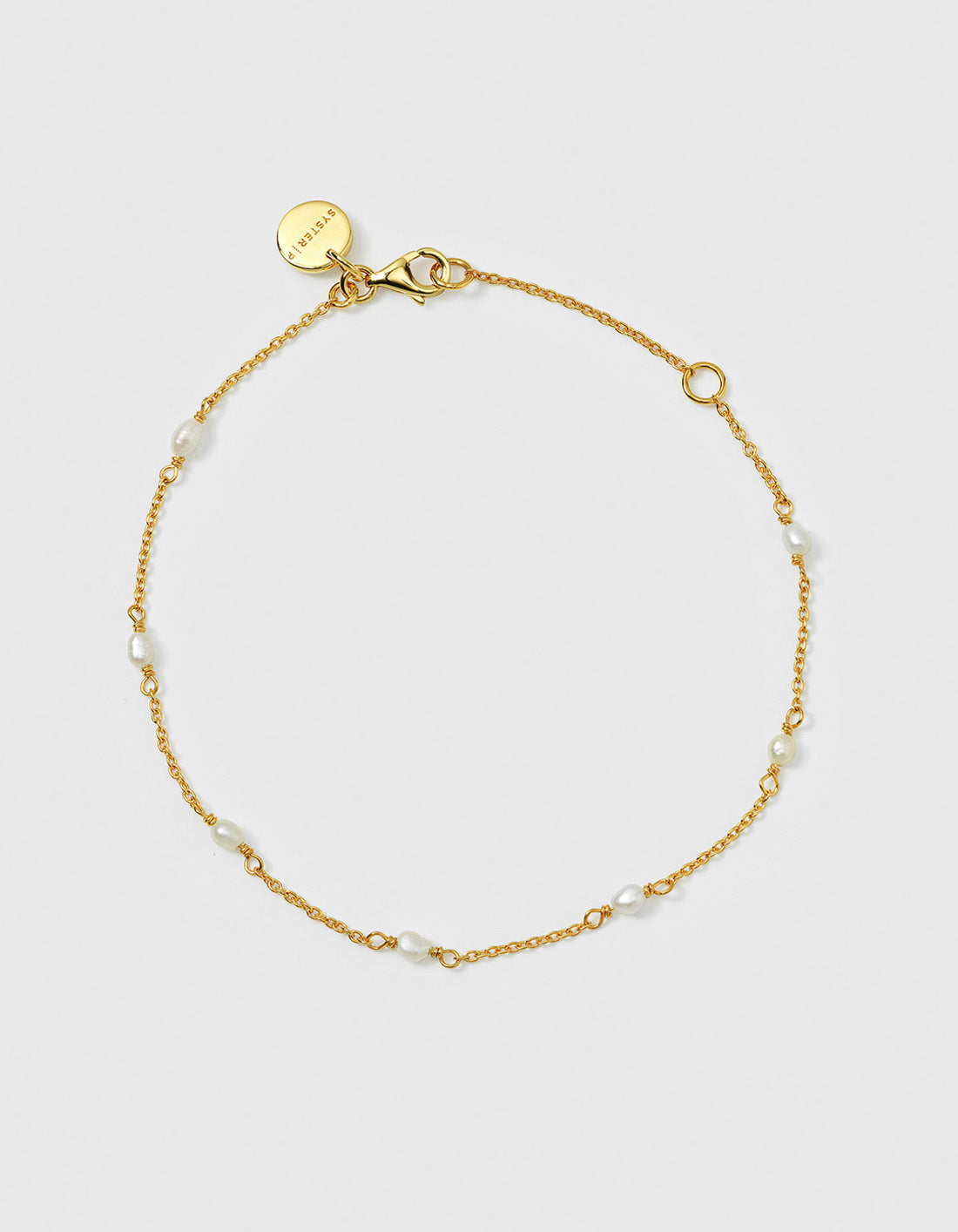 A product shot of the Treasure Multi Pearl Bracelet in gold, laid out in a circle to display its delicate chain adorned with small freshwater pearls spaced thorughout.