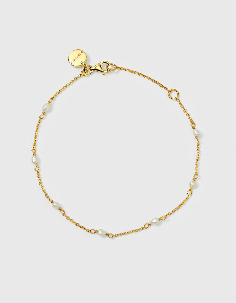 A product shot of the Treasure Multi Pearl Bracelet in gold, laid out in a circle to display its delicate chain adorned with small freshwater pearls spaced thorughout.