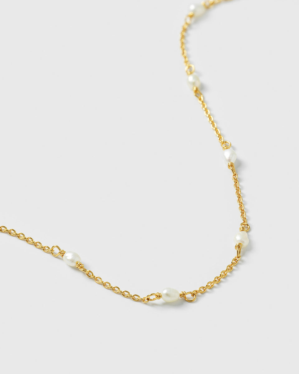 A close-up shot of the Treasure Multi Pearl Bracelet in gold, highlighting its delicate chain adorned with small freshwater pearls.