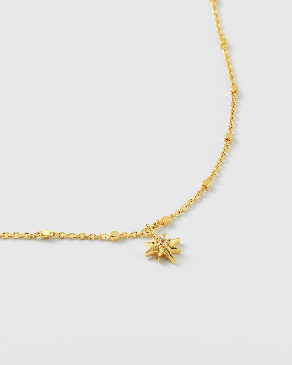 A product shot of the North Star Bracelet in gold, highlighting the unique chain and the star charm which is set with a small, faceted crystal.