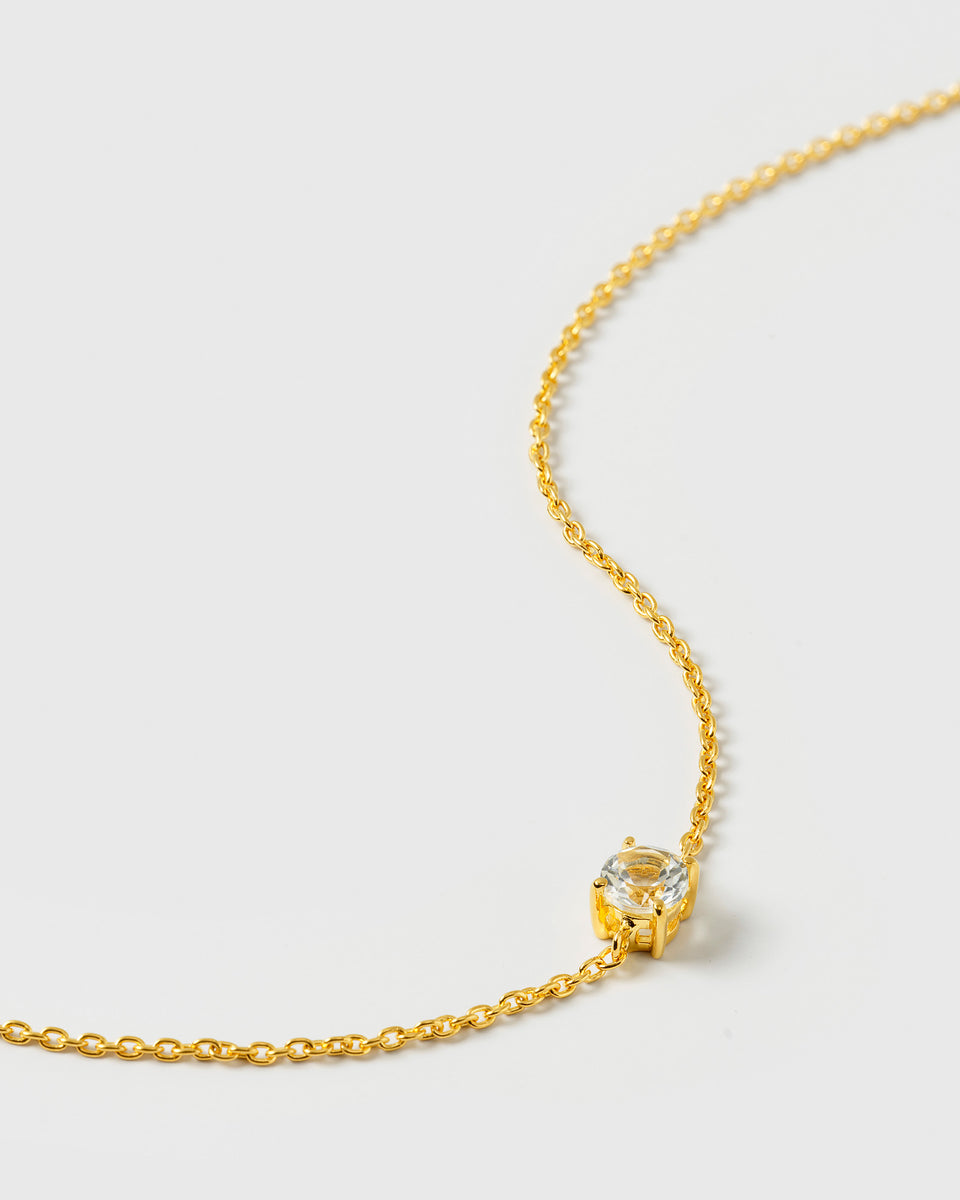 A close-up product shot of the Minimalistica Solo Nova Bracelet in gold, highlighting its delicate chain and the single, round white topaz.