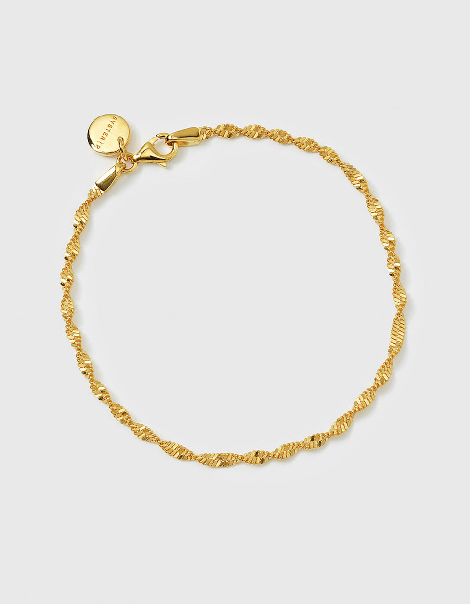 A product shot of the Syster P Herringbone Twisted Bracelet in gold, laid out in a circle to display its intricate twisted chain design.
