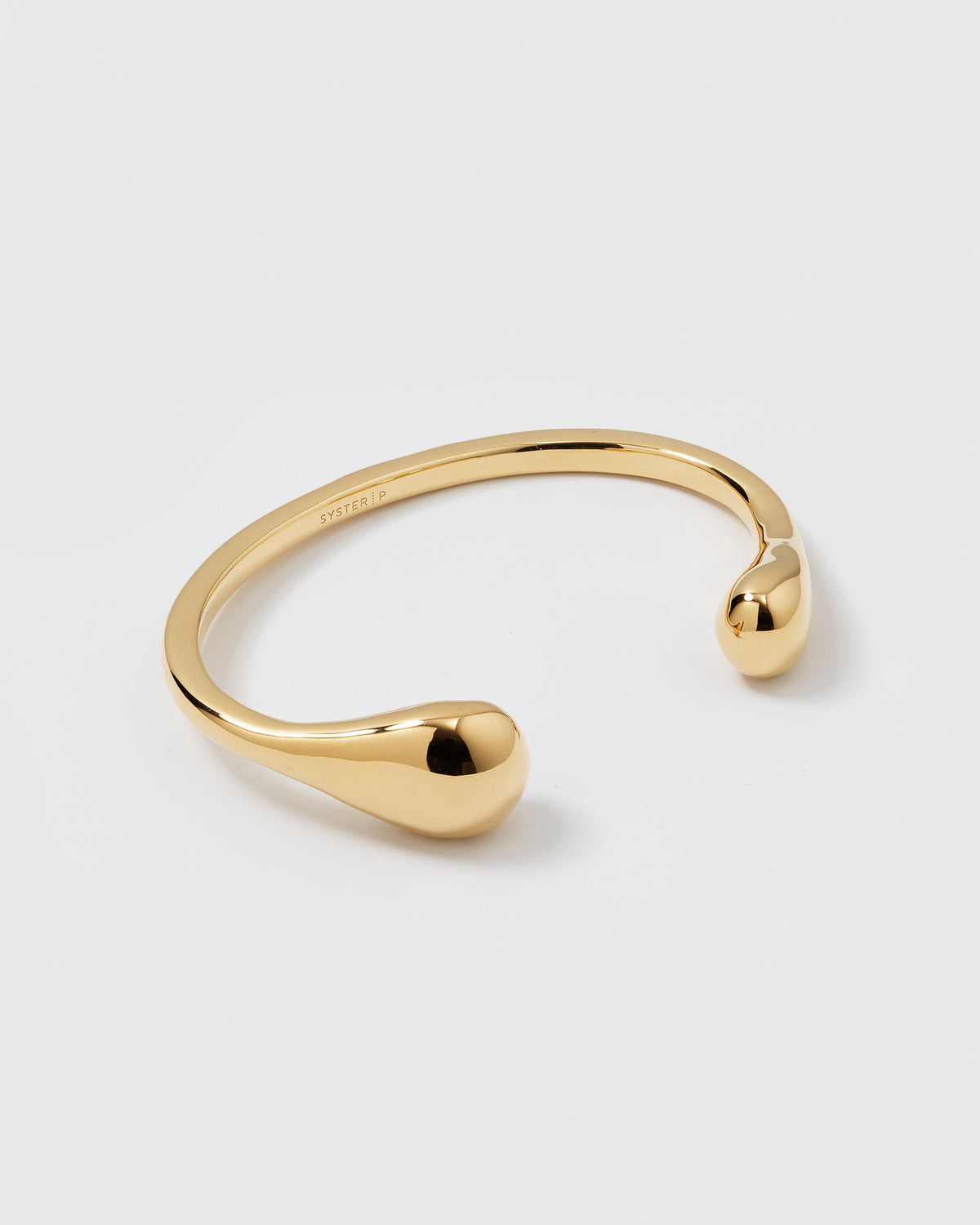 A product shot of the Bolded Drops Bangle in gold, showcasing its cuff design with two bold, drop-shaped ends.