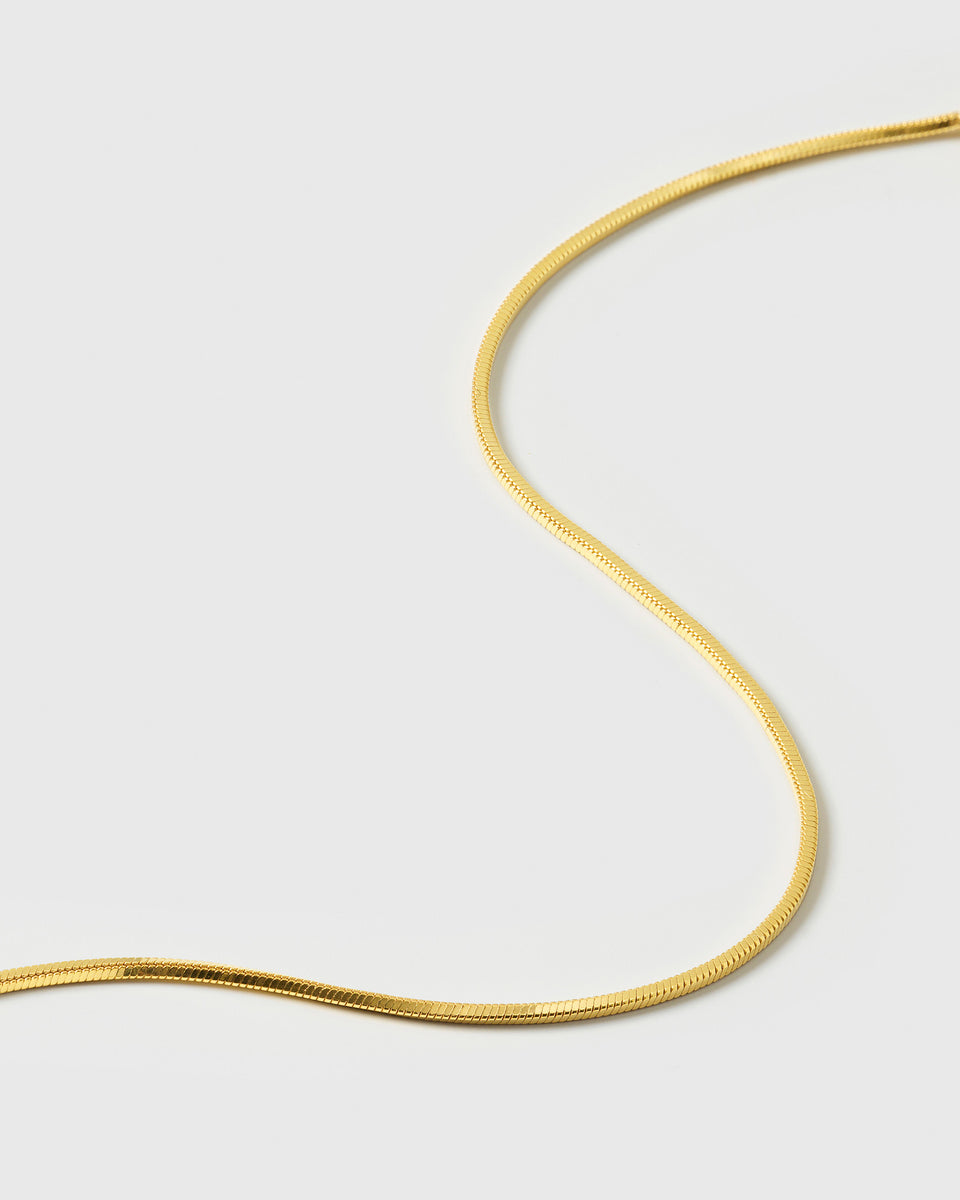 A product shot of the Sheer Mirror Bracelet in gold, showcasing its delicate and smooth snake chain.
