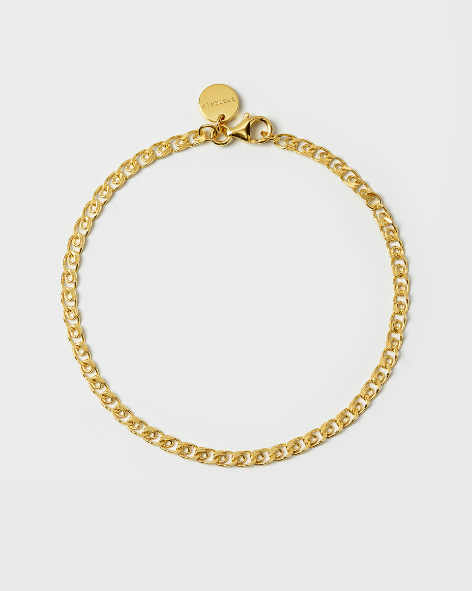 A product shot of the Sheer Love Bracelet in gold, laid out in a circle to showcase its unique patterned link chain, lobster clasp, and small Syster P branded tag.
