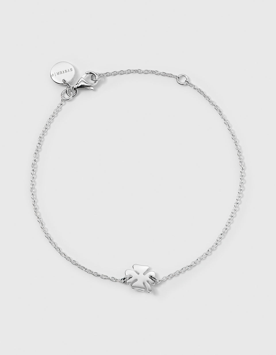 A product shot of the Bring Me Luck Bracelet in silver, laid out in a circle to display its delicate chain and central four-leaf clover pendant.