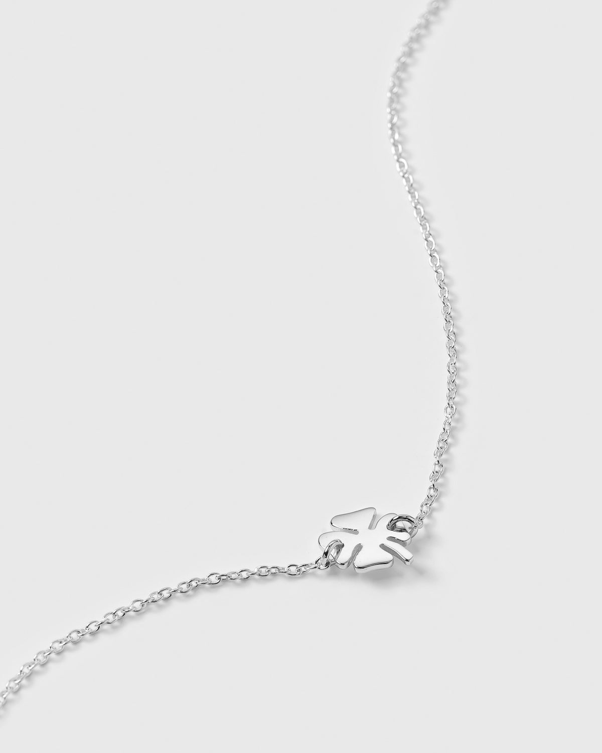 A product shot of the Bring Me Luck Bracelet in silver, featuring a delicate chain with a small four-leaf clover charm.