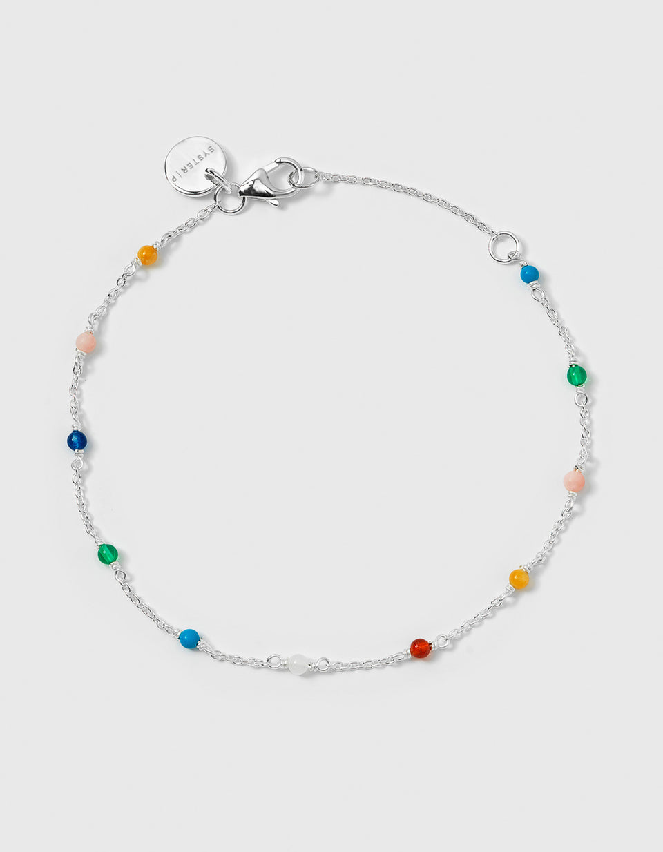 A product shot of the Santa Monica Bracelet in silver, laid out in a circle to display its design of a fine chain adorned with small, colorful gemstone beads: Yellow Jade, Pink Opal, Sodalite, Green Onyx, Blue Color Reconstituted Turquoise, Vit Agate and Carnelian.
