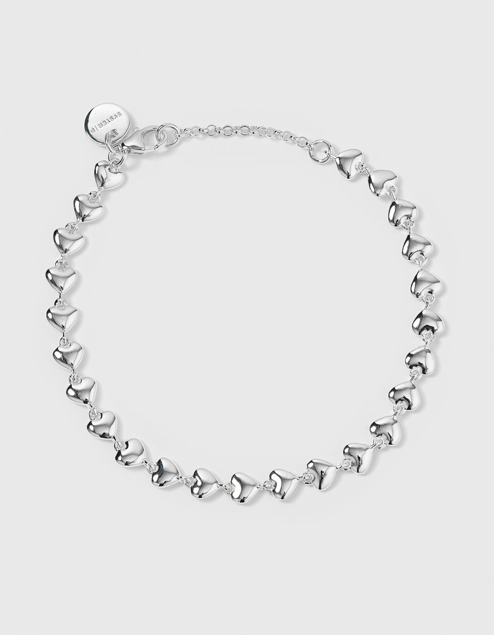 A product shot of the Darling Bracelet in silver, laid out in a circle and showing its design of a chain made entirely of small, interconnected hearts.