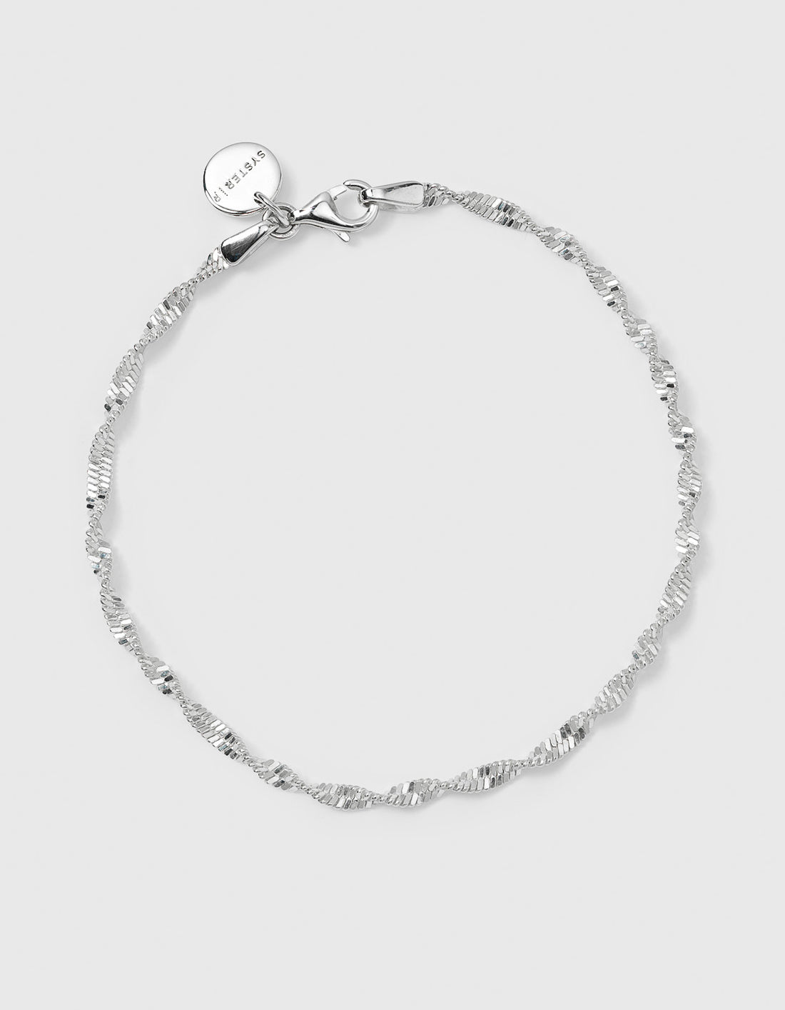 A product shot of the Herringbone Twisted Bracelet in silver, laid out in a circular shape to display its delicate, twisted design and clasp.