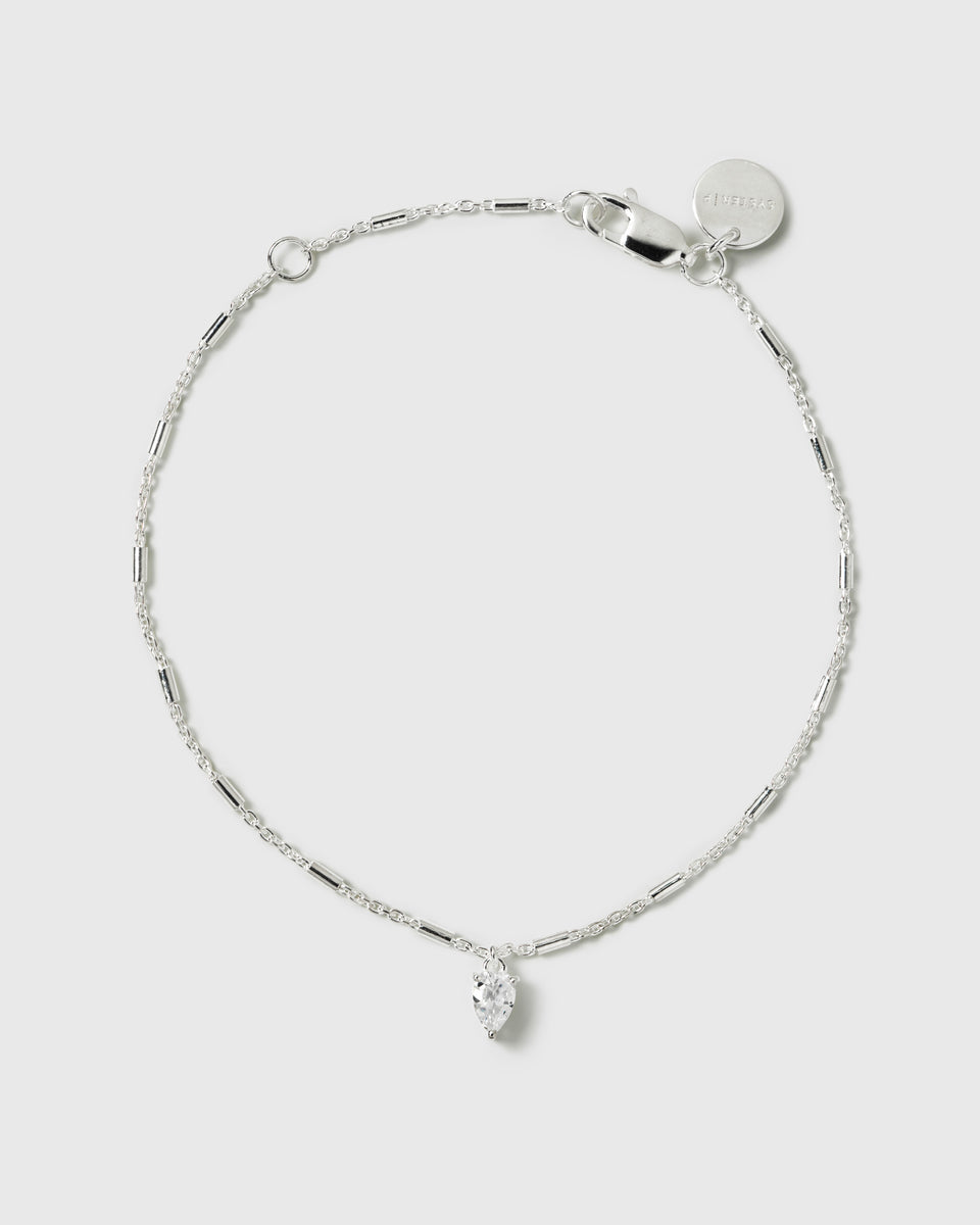A product shot of the Katie Bracelet in silver, laid out in a circle to display its delicate chain design with small bar details and a drop-shaped cubic zirconia charm.