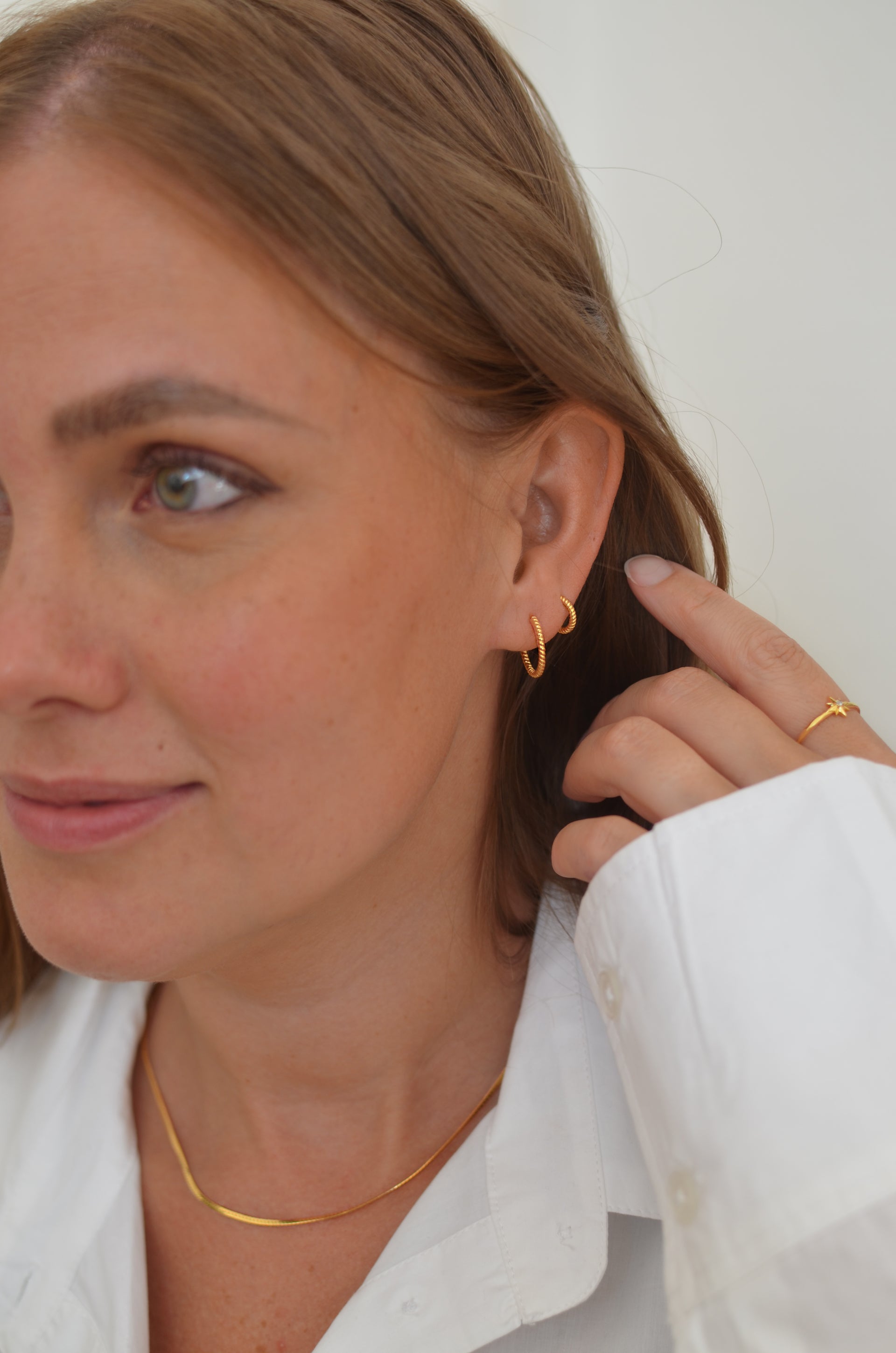 To twisted gold hoops in two different sizes, one medium and one small