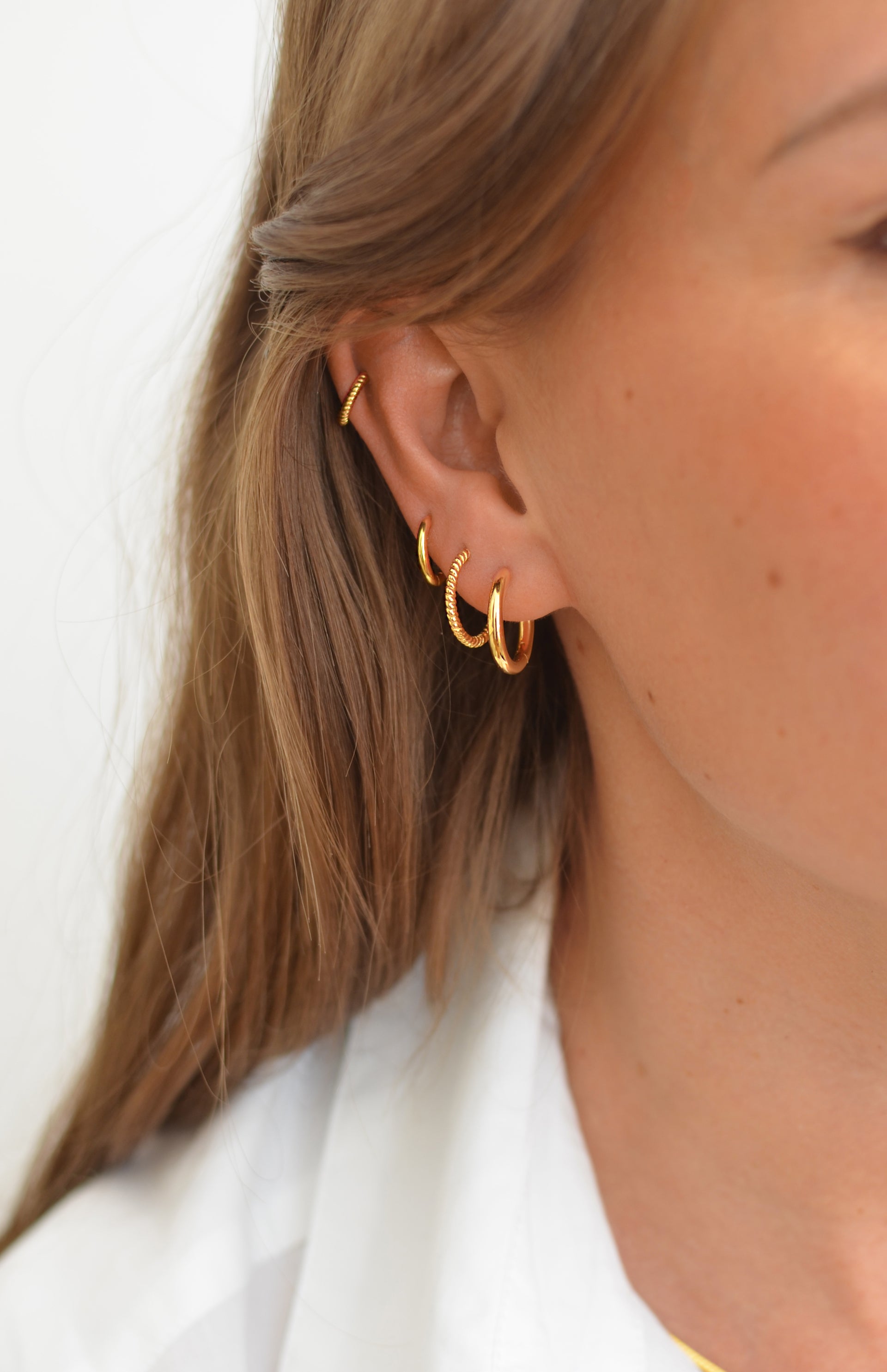 The hoops stacking with gold hoops in different sizes and two twisted gold hoops