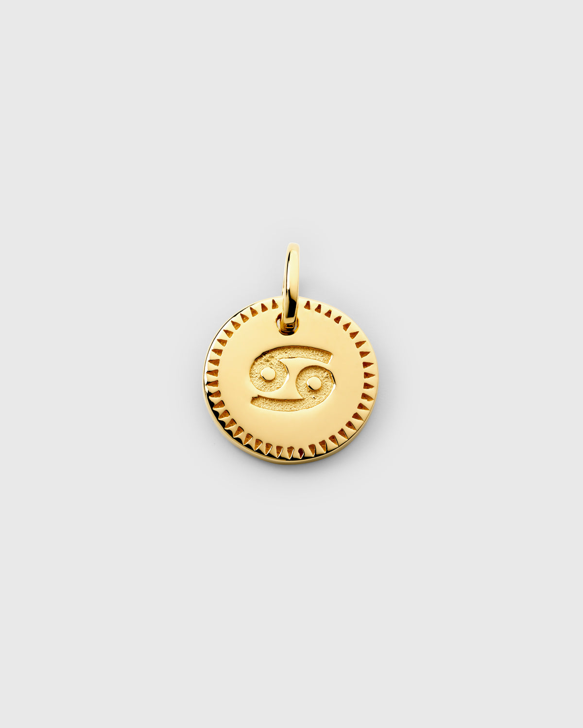 A product shot of the gold Beloved Zodie Pendant, showcasing the Cancer variant. The round charm has the Cancer zodiac symbol engraved in the center and is framed by a decorative border.