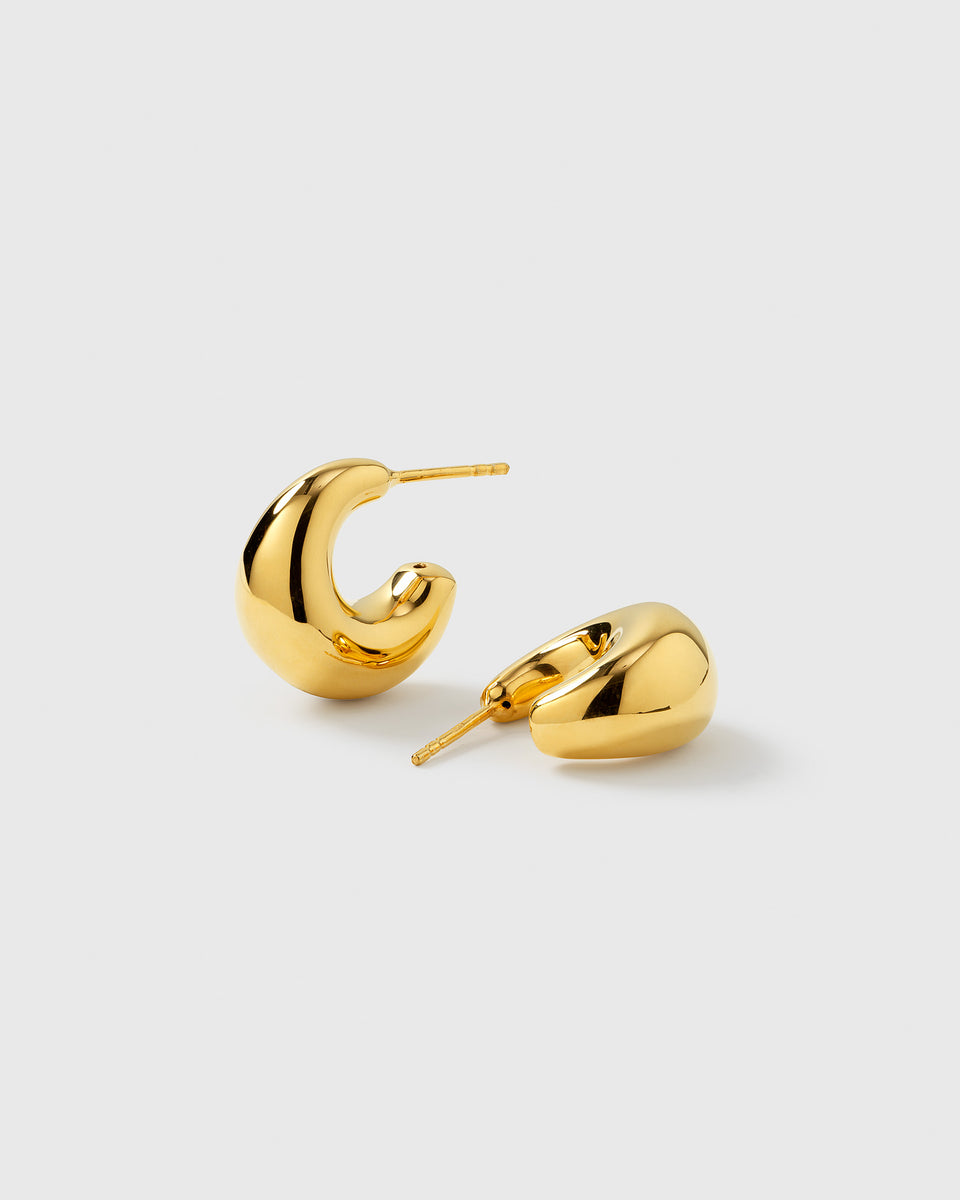 A product shot of the Bolded Little Sis Earrings in gold, showcasing the pair's chunky and polished C-shaped design.