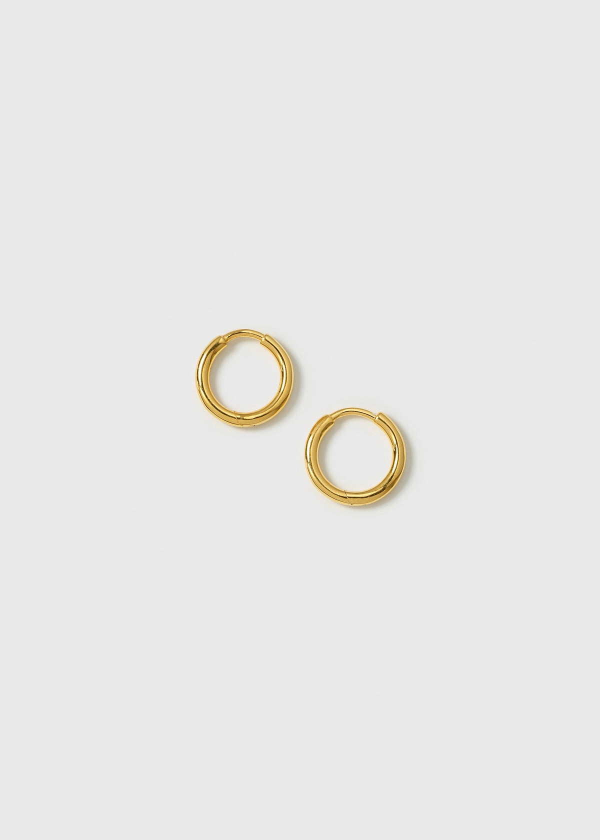 A product shot of the Beloved Fat Small Hoops Gold, highlighting their classic and thick circular design.