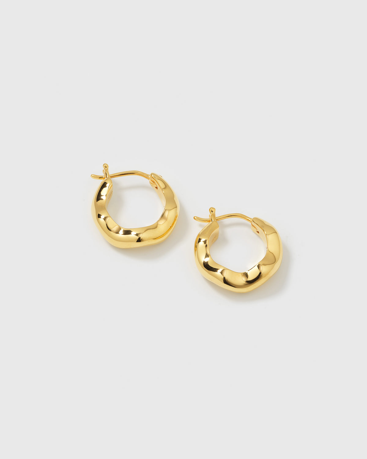 A product shot of the Bolded Wavy Earrings in gold, showcasing their shiny finish and unique wavy hoop design.