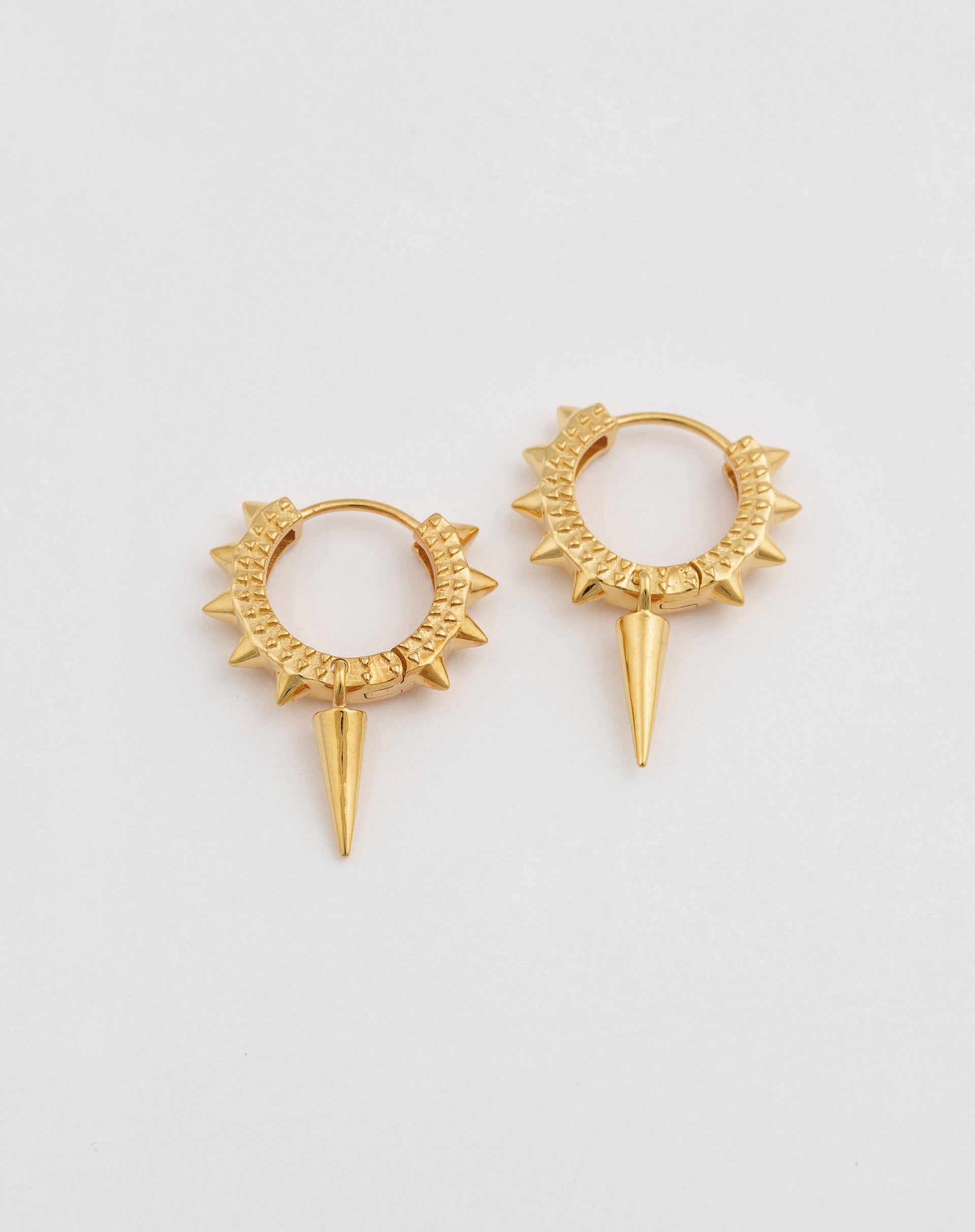 Gold earrings with textured sides and spike detailing