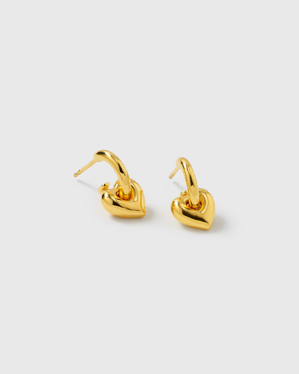 A pair of gold La La Love Fat Heart Earrings, featuring small hoops with a chunky, polished heart pendant.