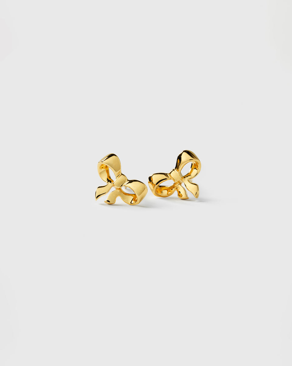 A product shot of the Rosie Mini Studs Gold, a pair of small stud earrings shaped like bows.