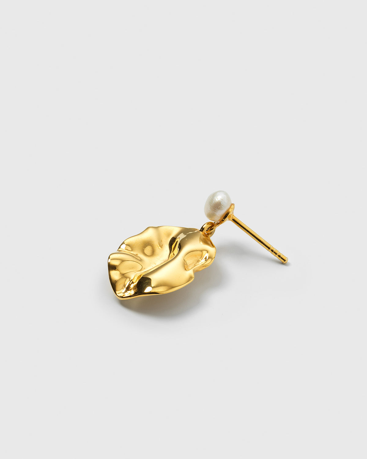 A product shot of the Moulded Short Single Earring in gold, featuring an organically shaped pendant with a moulded texture and a small freshwater pearl.