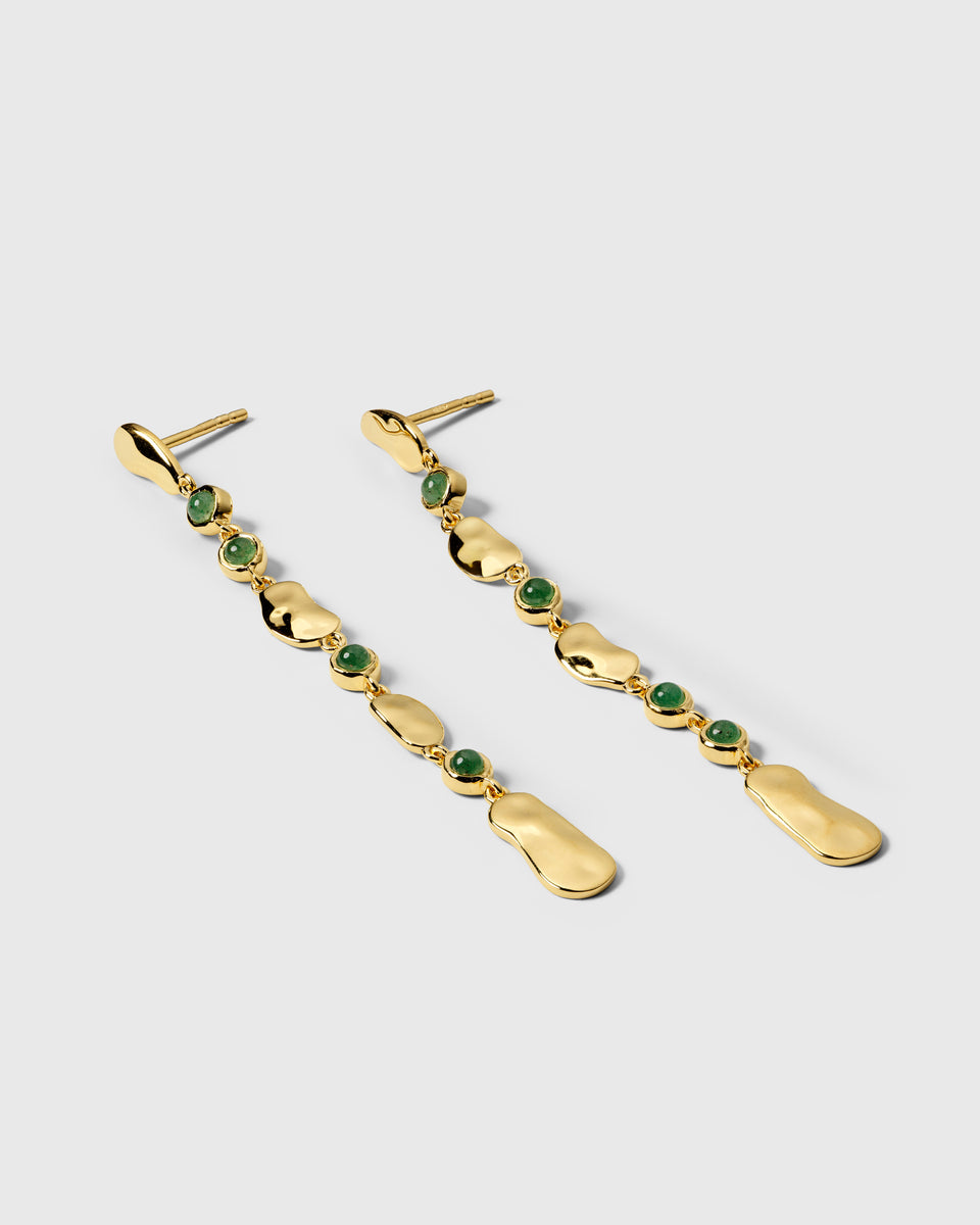 A product shot of the Florentina Long Earrings in gold and green jade, laid out to display their long, dangling design of alternating hammered gold plates and green jade stones.