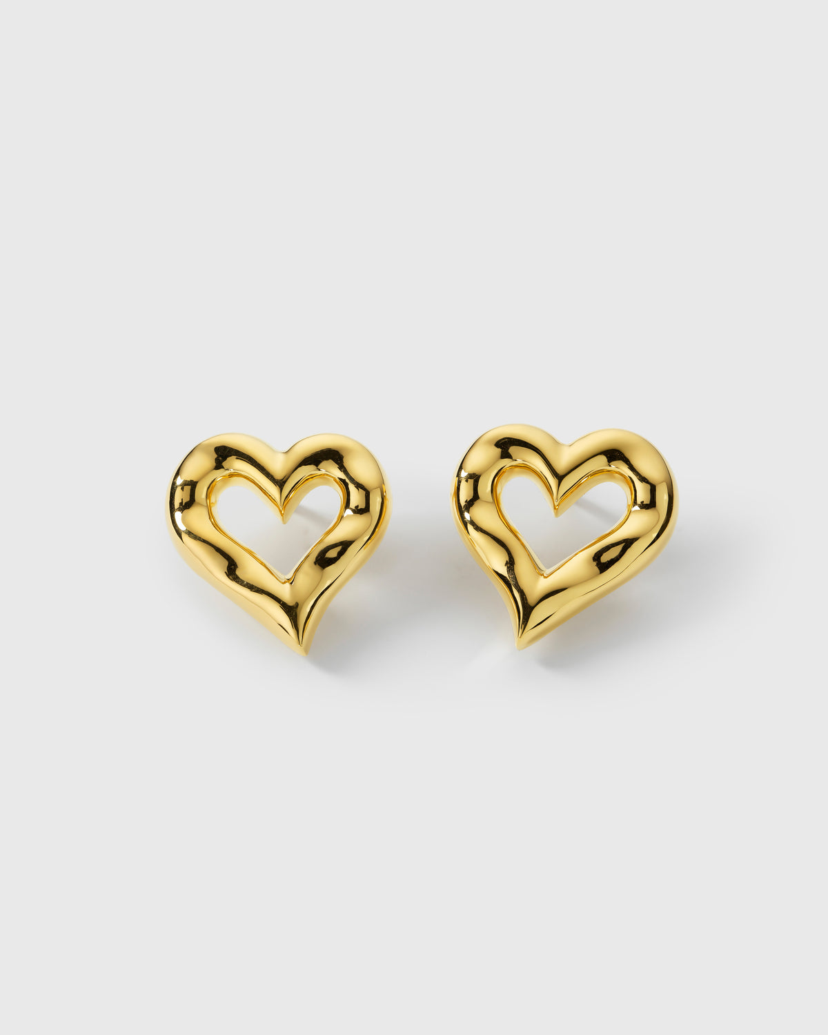 A product shot of the Puff Heart Earrings in gold, showcasing their chunky, organic heart design.