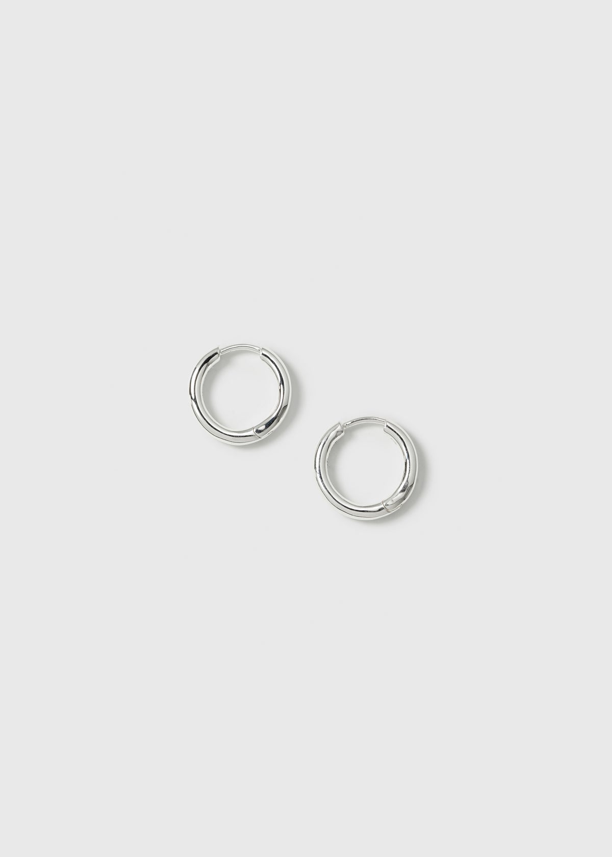 A product shot of the Beloved Fat Small Hoops in silver, a pair of classic, small, and thick hoop earrings.