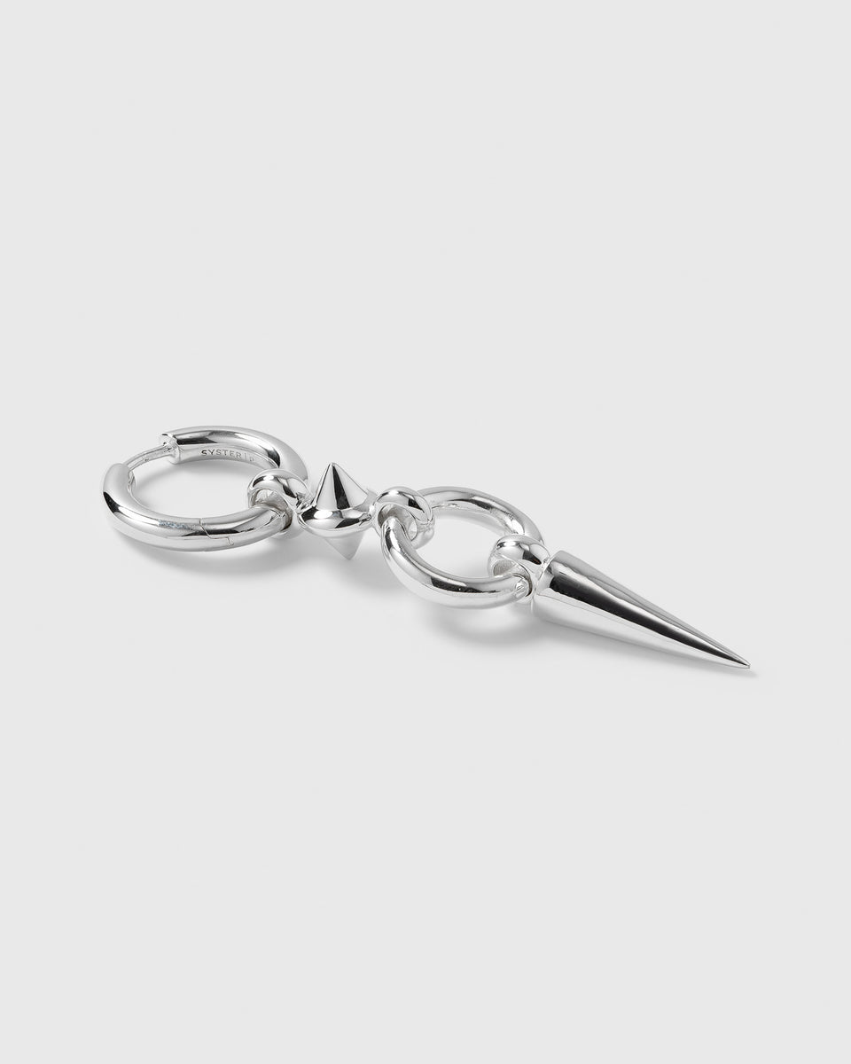 A product shot of the Juno Long Single Earring in silver, showcasing its edgy design featuring a chunky hoop, a small spike, and a long, dangling spike.