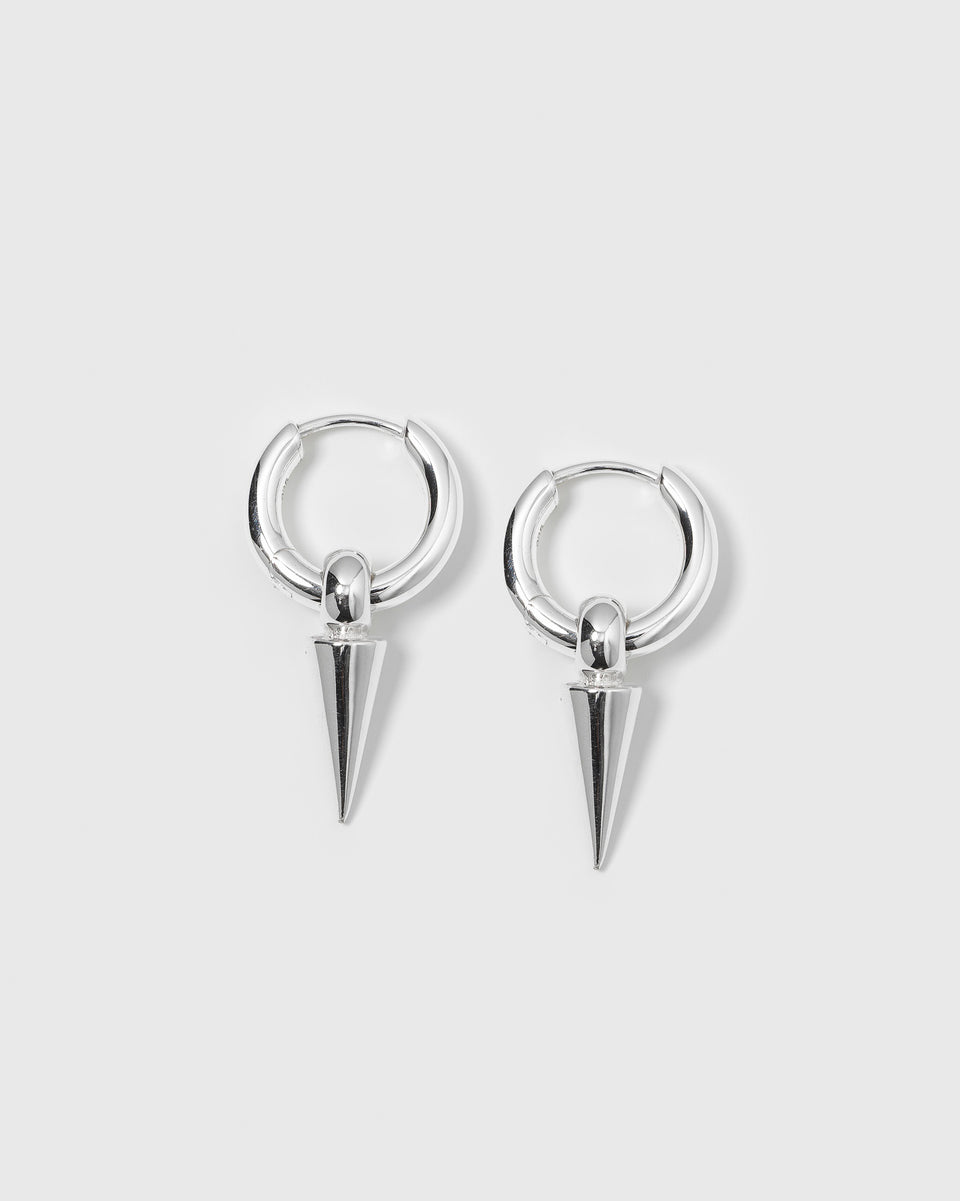 A product shot of the Juno Hoops in silver, featuring a pair of small hoop earrings with dangling, cone-shaped spike pendants.