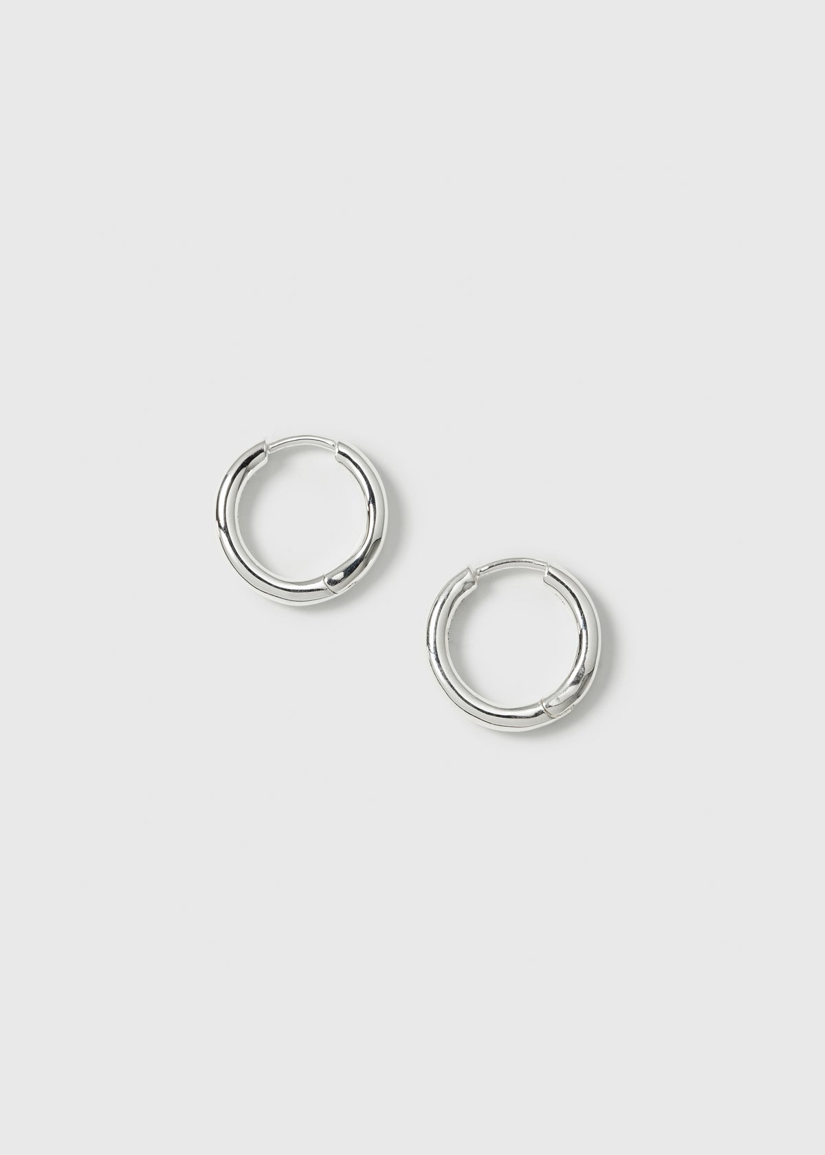 A product shot of the Beloved Fat Medium Hoops in silver, laid out to display their classic and chunky design.