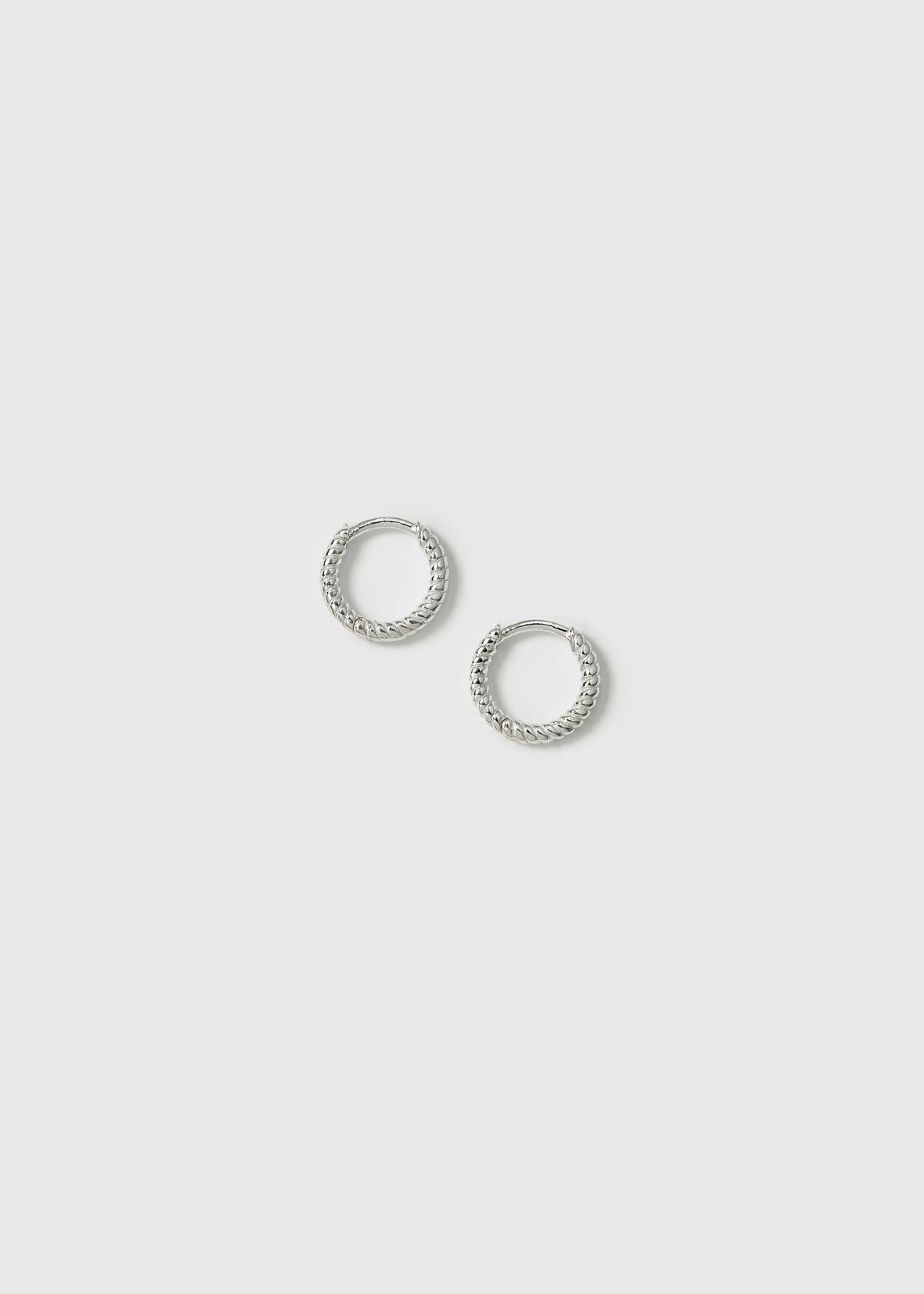 A product shot of the Beloved Twisted Small Hoops in silver, highlighting their unique twisted design.