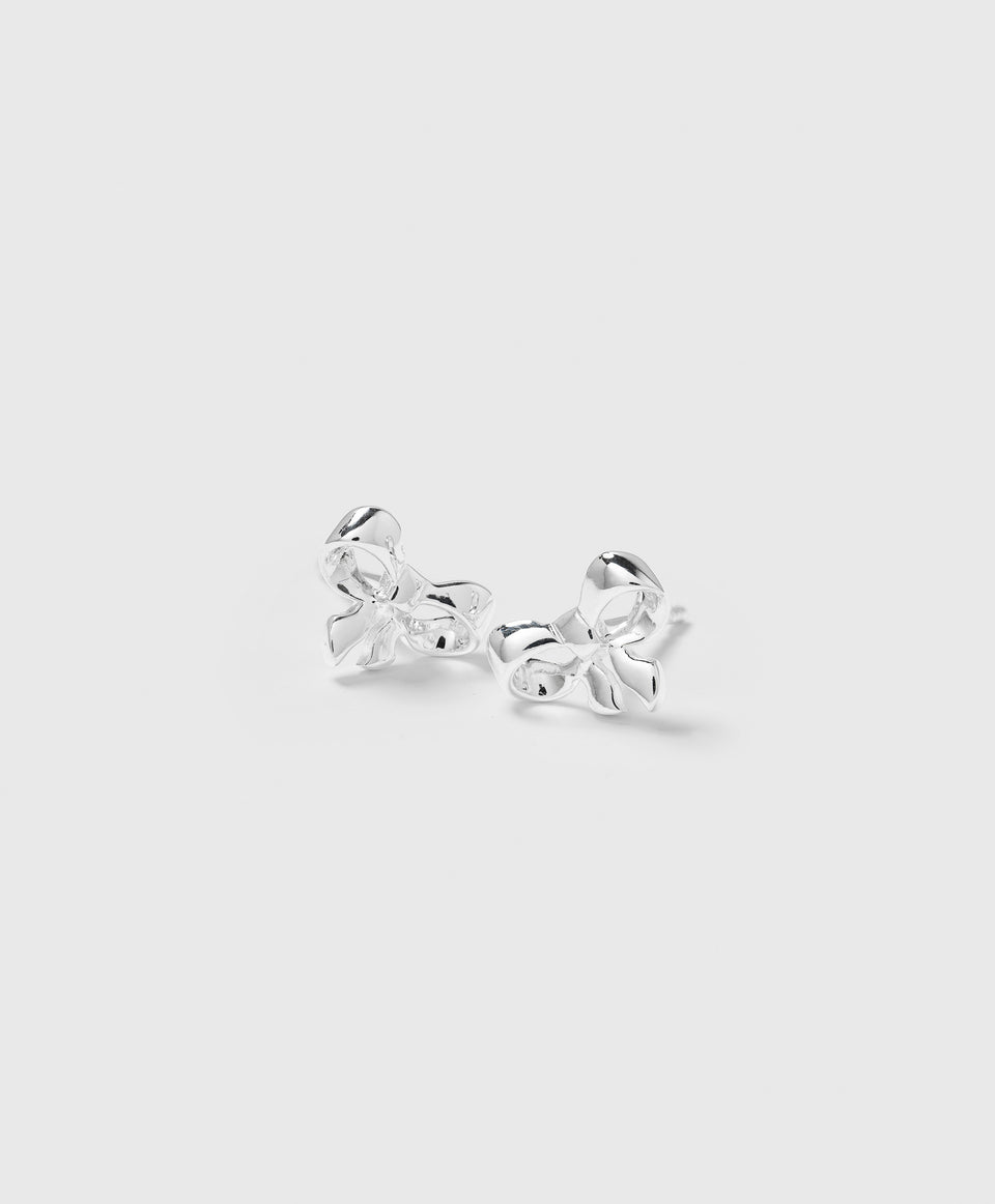 A product shot of the Rosie Mini Studs in silver, featuring a delicate bow-shaped design.