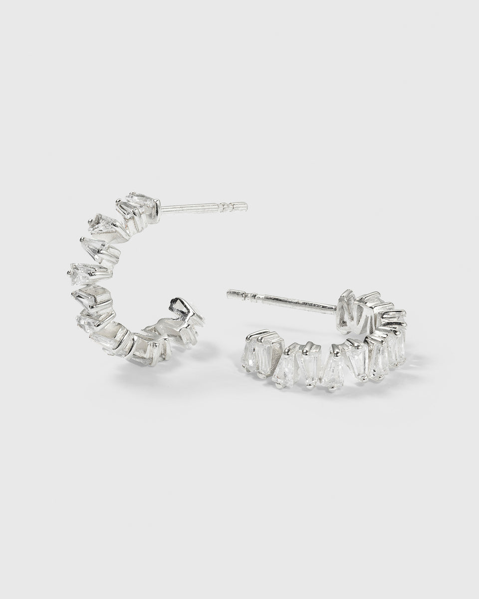 A product shot of the Iggy Earrings in silver, featuring a C-hoop design adorned with tapered baguette-cut cubic zirconias.