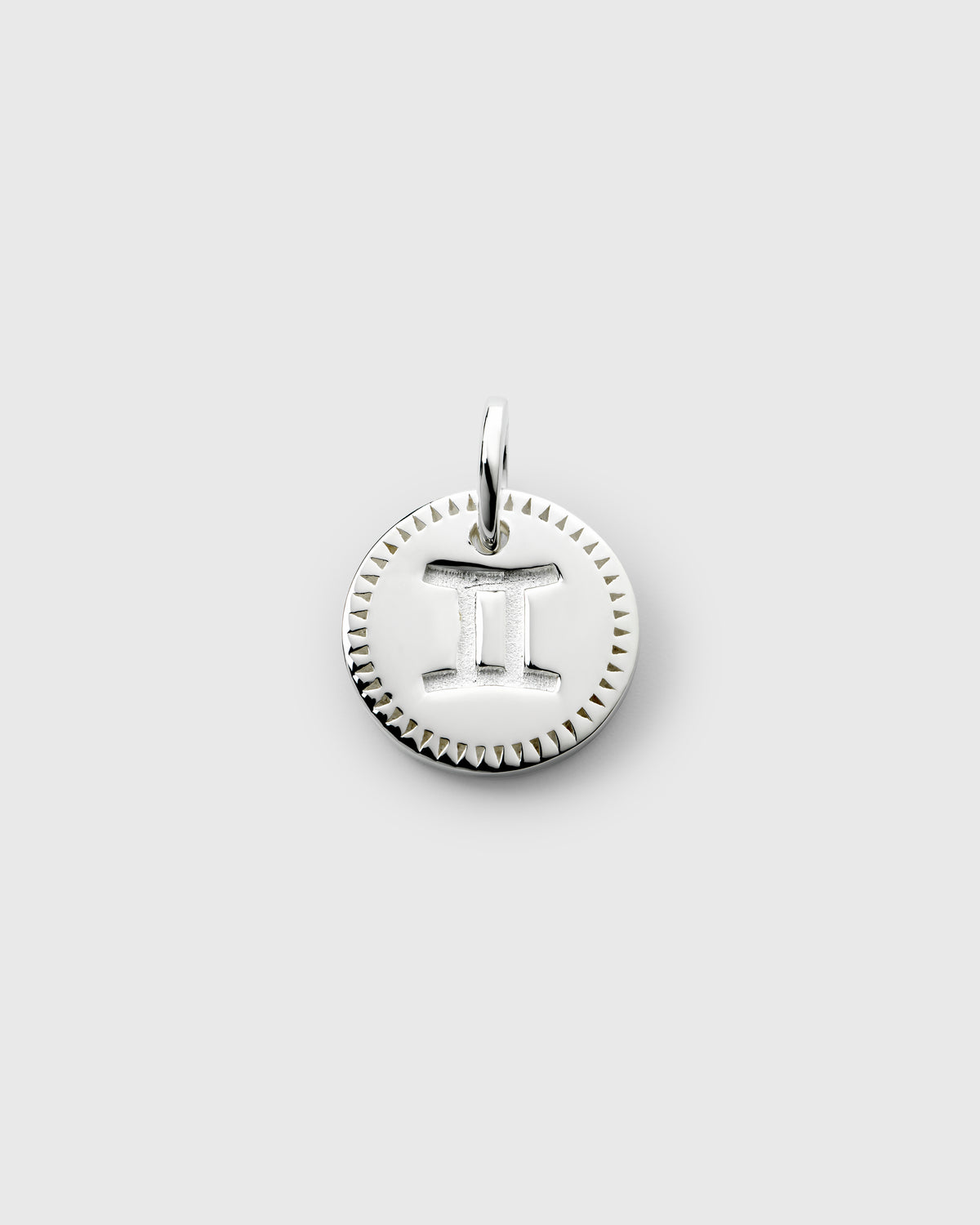A product shot of the Beloved Zodie Pendant in silver, featuring the engraved zodiac symbol for Gemini on a round charm with a decorative border.