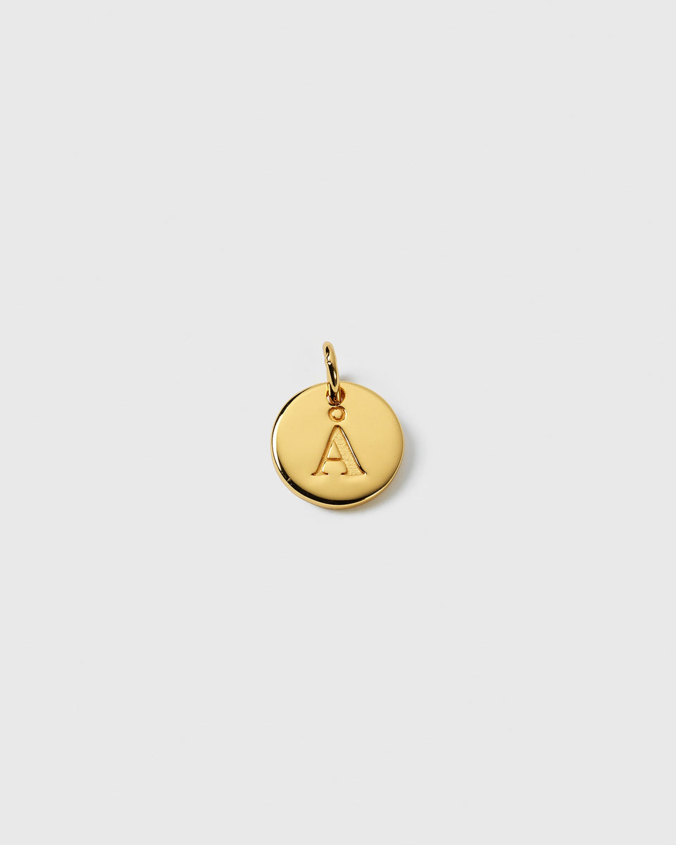 A product shot of the Beloved Mini Letter Gold charm, showing the small, round pendant with the initial 'A' engraved on it.