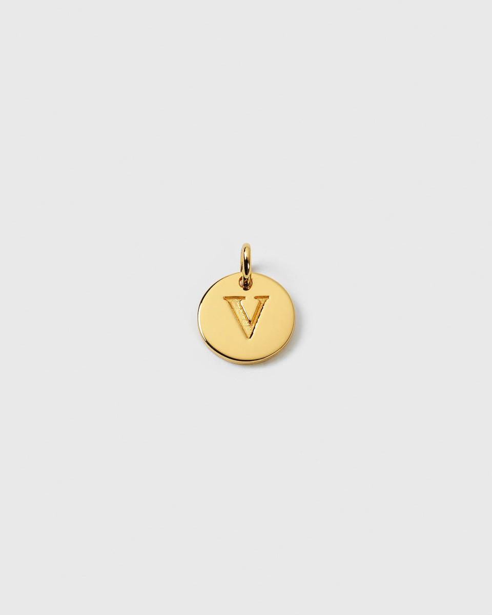 A product shot of the Beloved Mini Letter V pendant in gold, featuring a small, circular charm with the letter engraved in the center.