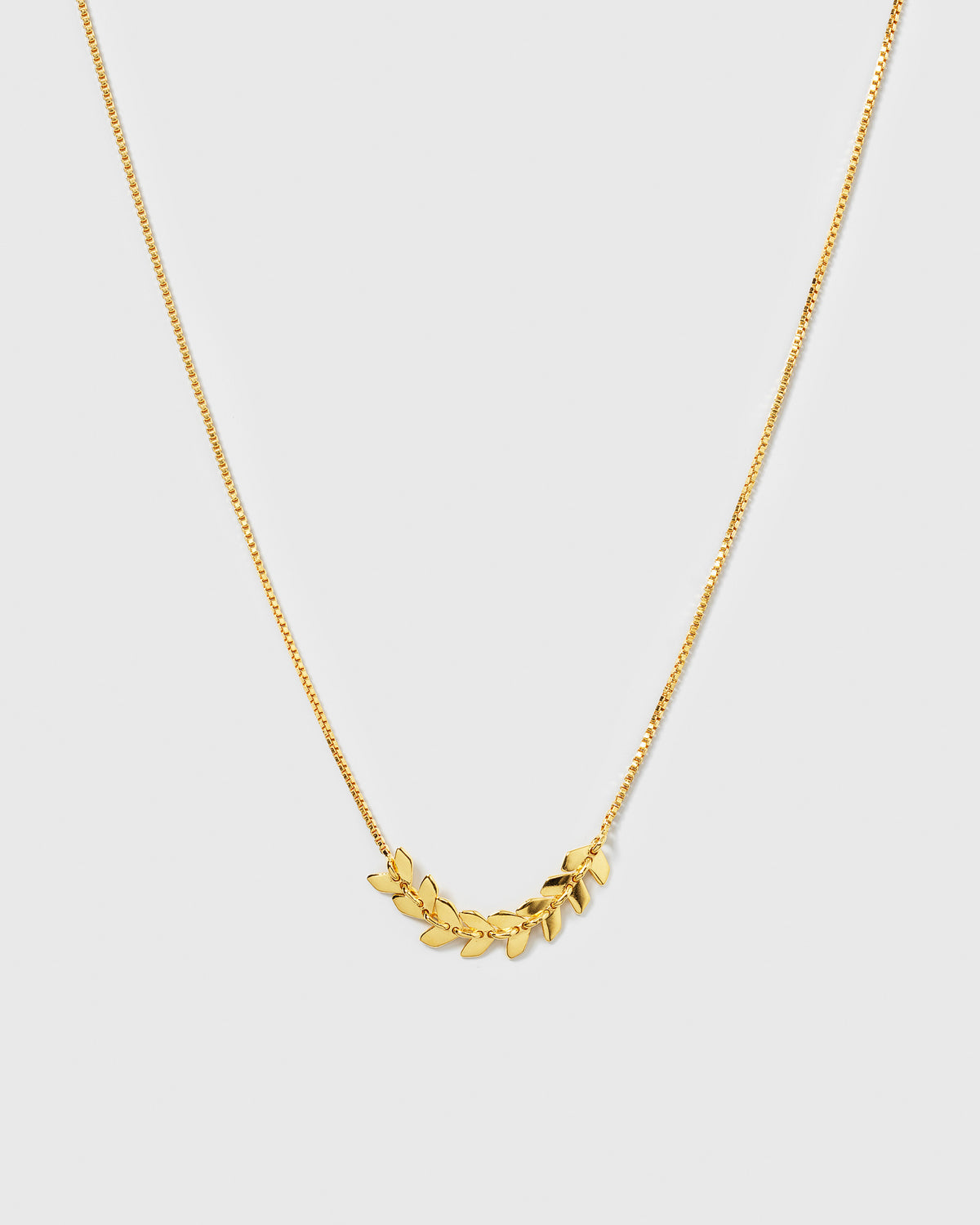 A product shot of the Layers Simone Necklace in gold, showing the full necklace with its fine chain and central detail of small, interconnected leaf-like shapes.