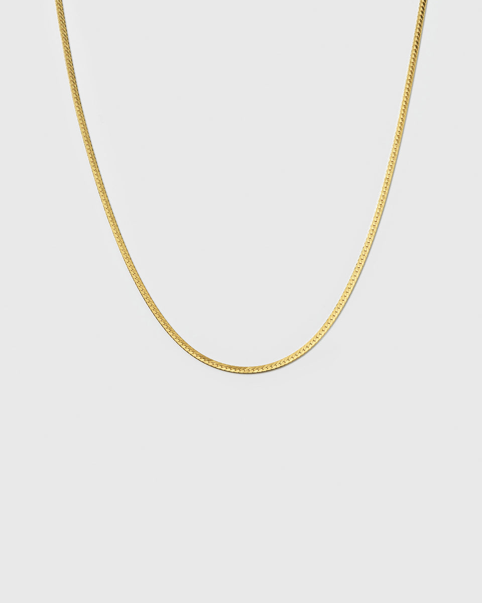 A product shot of the Herringbone Necklace Gold, highlighting its smooth, delicate, and flat chain with a classic herringbone pattern.