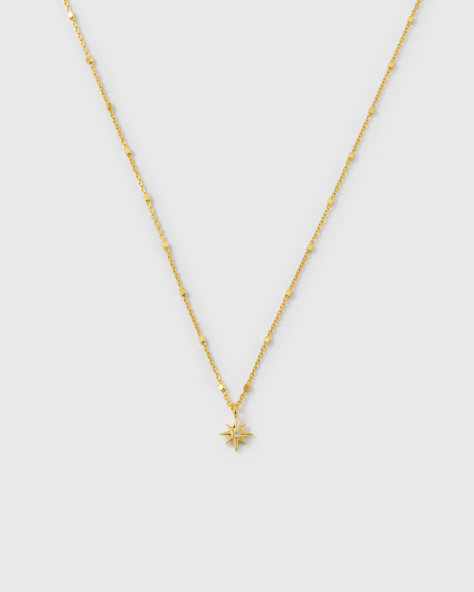 A product shot of the North Star Necklace in gold, featuring a unique, delicate chain and a star-shaped pendant set with a clear crystal.