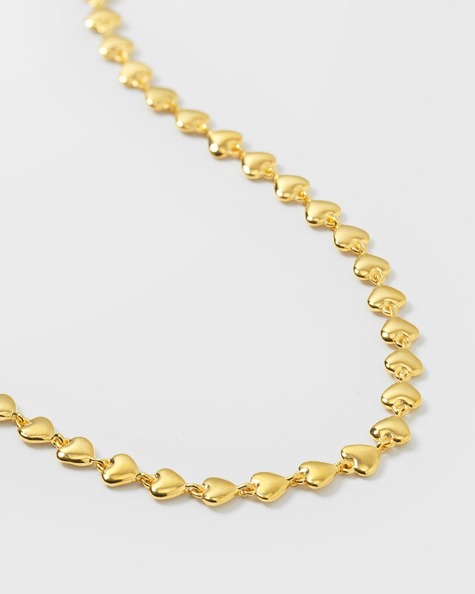 A product shot of the Darling Necklace in gold, providing a close-up view of its chain which is made from a series of small, interconnected hearts.