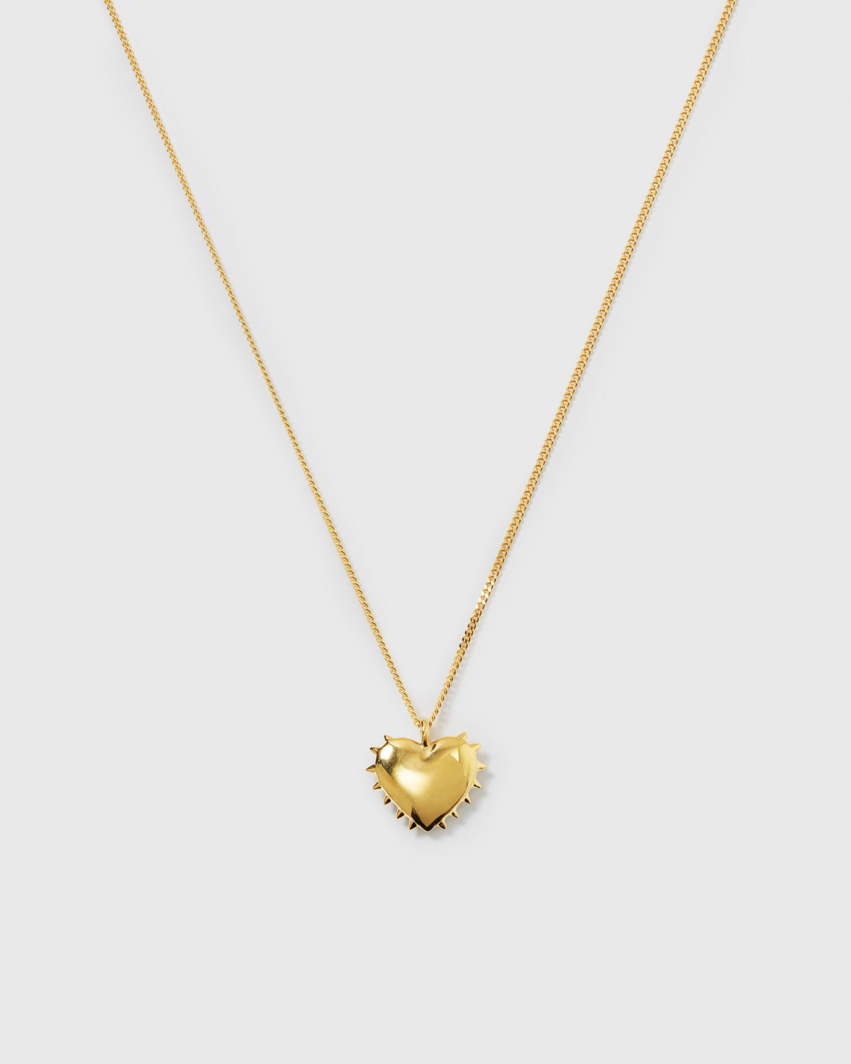 A product shot of the True Love Spike Heart Necklace in gold, featuring a chain and a heart-shaped pendant with small spikes around its edge.
