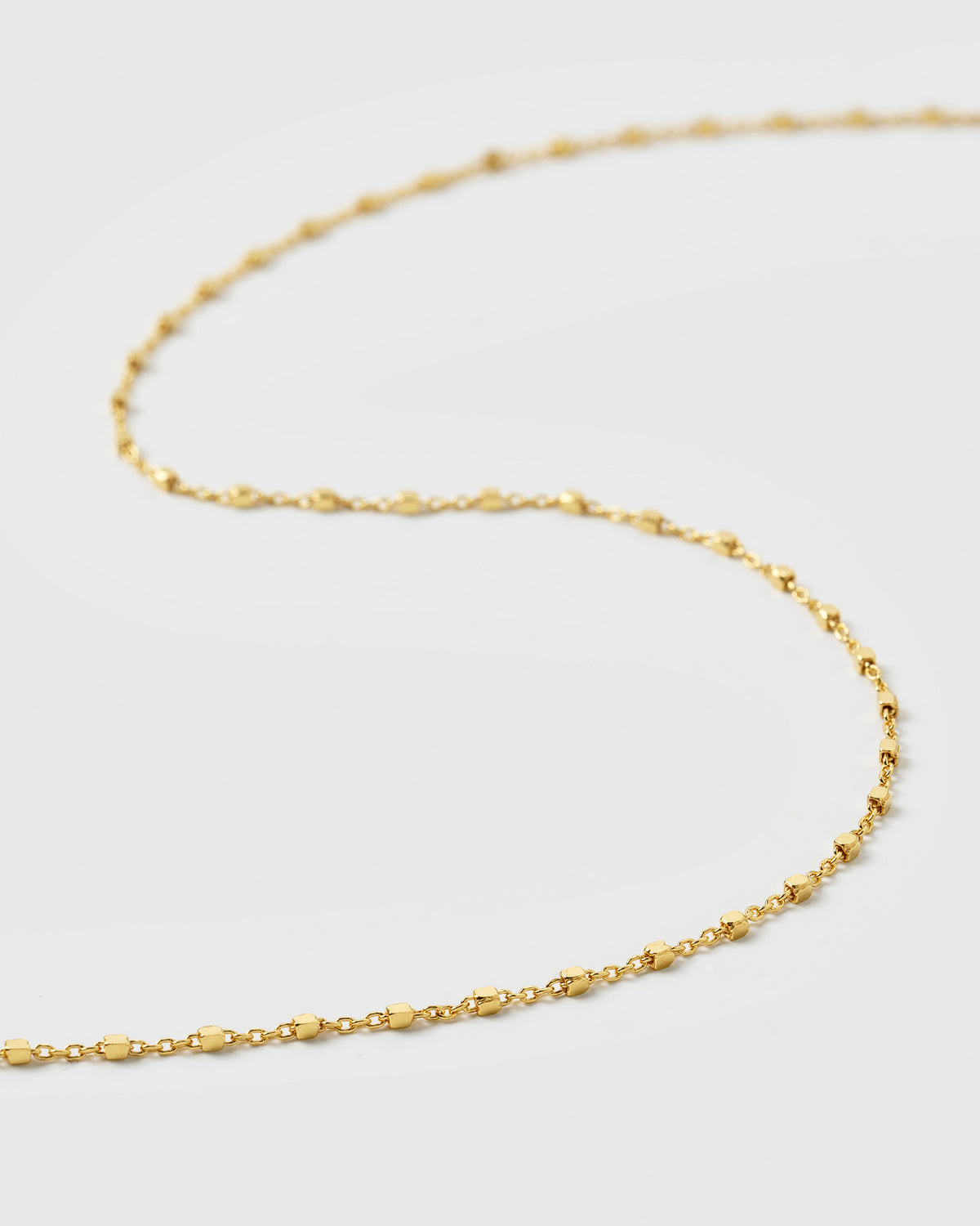 A product shot of the Sheer Station Necklace in gold, featuring its delicate chain design with small, evenly spaced dots.