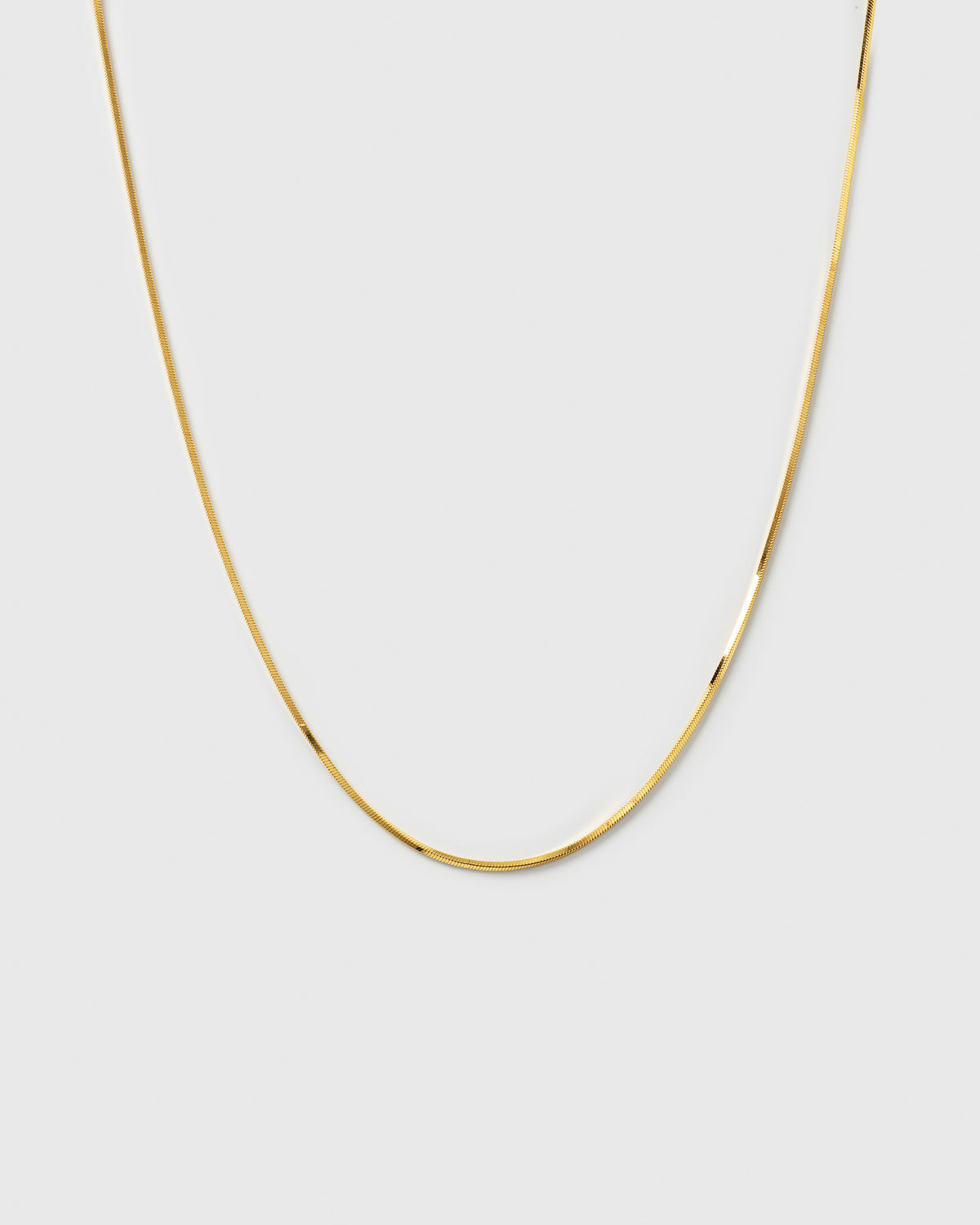 A product shot of the Sheer Mirror Necklace in gold, showcasing its delicate and smooth snake chain design.