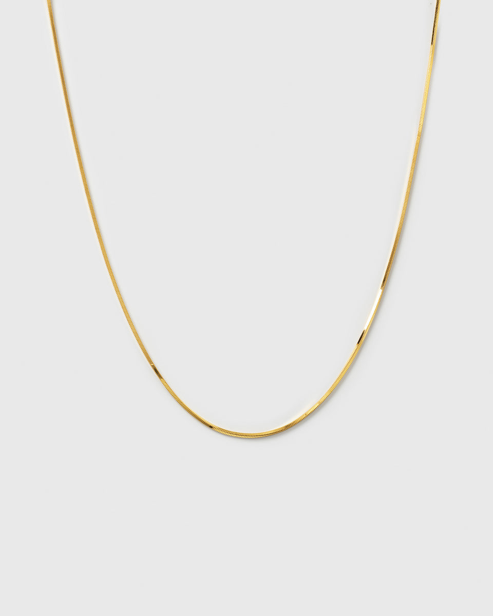 A product shot of the Sheer Mirror Necklace in gold, showcasing its delicate and smooth snake chain design.
