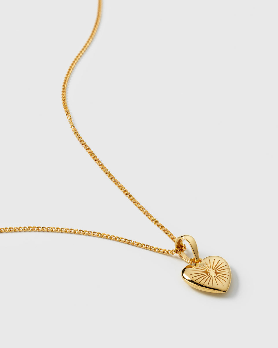A close-up product shot of the Sunburst Heart Necklace in gold, highlighting the intricate sunburst pattern on the heart-shaped pendant and the delicate chain.